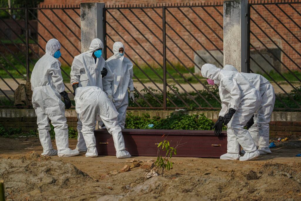 Trabajadores efectúan un funeral de una víctima del Covid-19 en Bangladesh