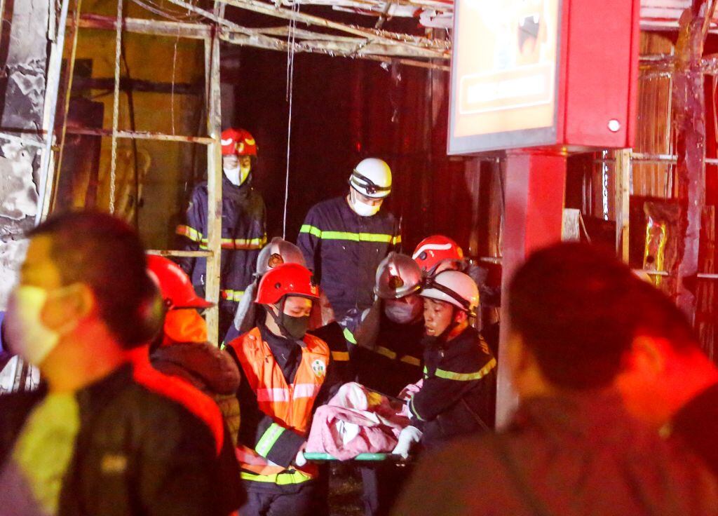 Rescatistas retiran un cuerpo del incendio que dejó once personas fallecidas al quemarse un bar de karaoke en la ciudad de Hanoi en Vietnam