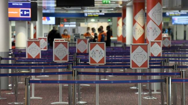 Placards with pictograms depicting Covid-19 sanitary instructions are pictured in a queueing area of the Terminal 2E's arrival level of the Roissy-Charles de Gaulle airport near Paris on March 18, 2021. (Photo by ERIC PIERMONT / AFP) (Photo by ERIC PIERMONT/AFP via Getty Images)