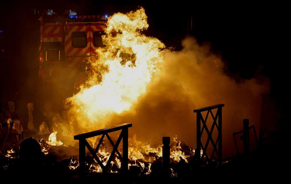 Bomberos intentan apagar una barricada en las calles de París en Francia