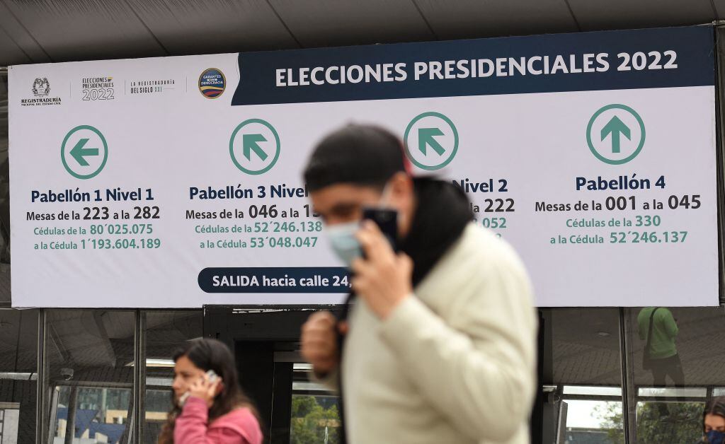 Hombre camina ante un informativo de las elecciones en Bogotá