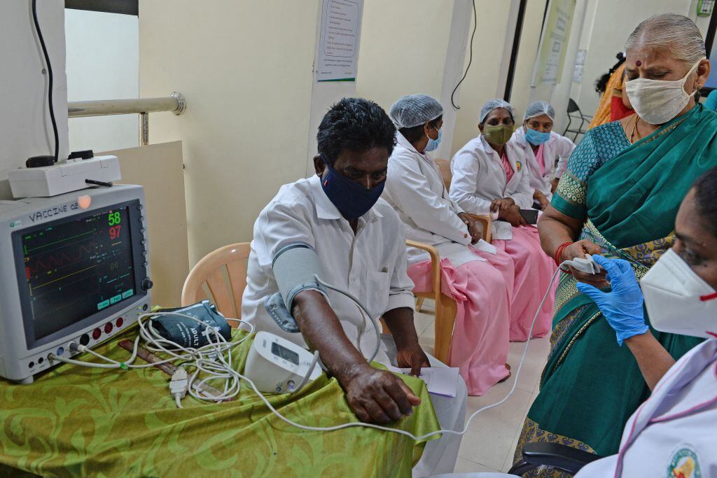Toman los signos vitales de un paciente antes de ser vacunado en Chennai