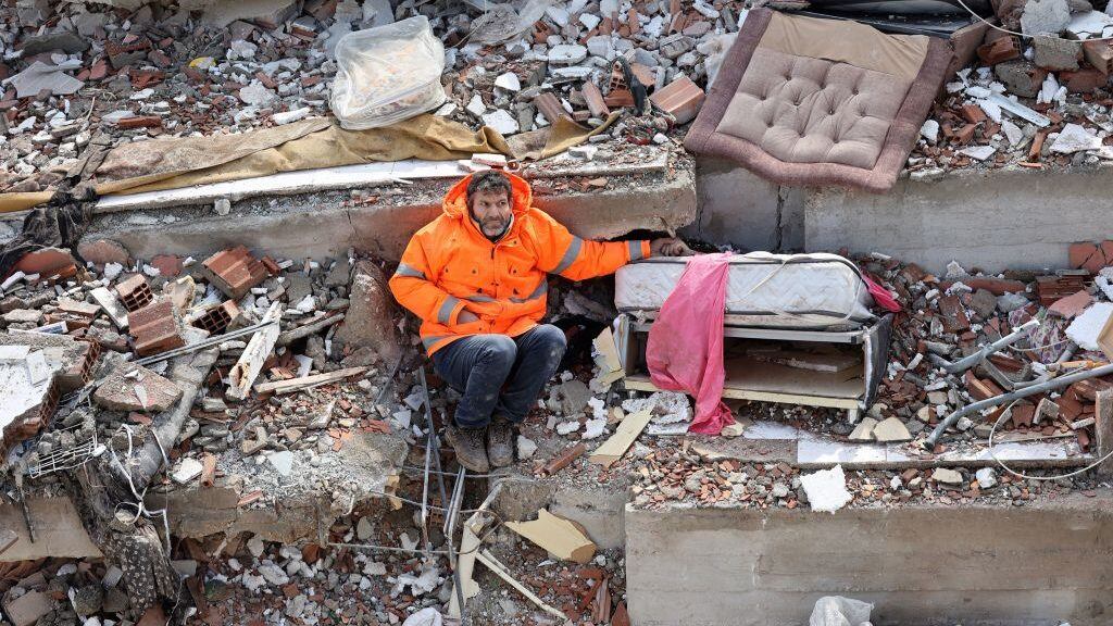 TOPSHOT - Mesut Hancer holds the hand of his 15-year-old daughter Irmak, who died in the earthquake in Kahramanmaras, close to the quake's epicentre, the day after a 7.8-magnitude earthquake struck the country's southeast, on February 7, 2023. - Rescuers in Turkey and Syria braved frigid weather, aftershocks and collapsing buildings, as they dug for survivors buried by an earthquake that killed more than 5,000 people. Some of the heaviest devastation occurred near the quake's epicentre between Kahramanmaras and Gaziantep, a city of two million where entire blocks now lie in ruins under gathering snow. (Photo by Adem ALTAN / AFP) (Photo by ADEM ALTAN/AFP via Getty Images)
