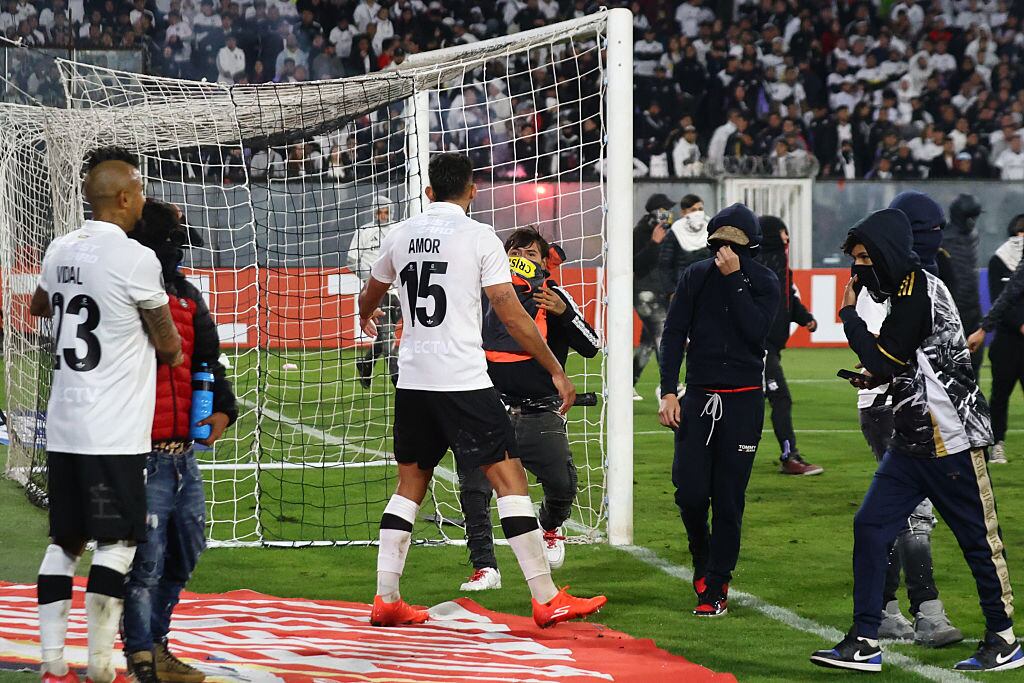 SANTIAGO, CHILE - APRIL 10: Fans enter the field as the match is suspended during the CONMEBOL Copa Libertadores group E match between Colo Colo and Fortaleza at Estadio Monumental David Arellano on April 10, 2025 in Santiago, Chile. (Photo by Marcelo Hernandez/Getty Images)