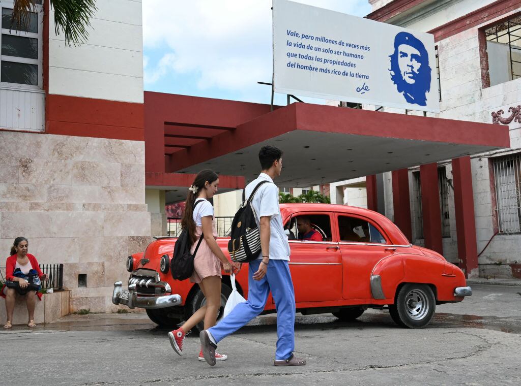 Dos personas caminan por la calle frente al Hospital Calixto Garcia en la ciudad de La Habana en Cuba.