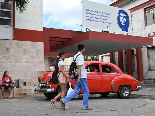 Dos personas caminan por la calle frente al Hospital Calixto Garcia en la ciudad de La Habana en Cuba.