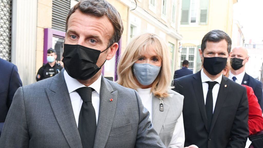 French President Emmanuel Macron (L), his wife Brigitte Macron (C) and the mayor of Valence Nicolas Daragon (R) walk in a street in Valence on June 8, 2021 during a visit in the French southeastern department of Drôme, the second stage of a nationwide tour ahead of next year's presidential election. (Photo by PHILIPPE DESMAZES / POOL / AFP) (Photo by PHILIPPE DESMAZES/POOL/AFP via Getty Images)