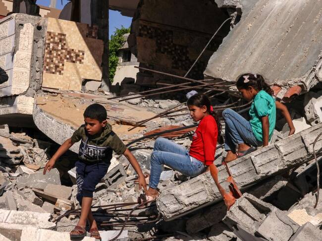 Niños palestinos juegan entre escombros que dejaron los ataques a Gaza