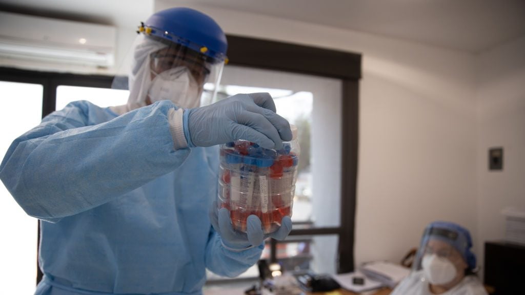 MEXICO CITY, MEXICO - JUNE 19: A doctor saves a package of samples from people with symptoms of COVID-19 to be sent to a laboratory at Central de Abastos on June 19, 2020 in Mexico City, Mexico. The temporary unit receives people with symptoms related to the coronavirus disease, patients are evaluated and redirected to a hospital if necessary. The Central de Abasto is the largest market in Mexico and Latin America, boasting financial transaction volumes only surpassed by The Mexican Stock Exchange. (Photo by Hector Vivas/Getty Images)