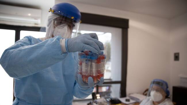 MEXICO CITY, MEXICO - JUNE 19: A doctor saves a package of samples from people with symptoms of COVID-19 to be sent to a laboratory at Central de Abastos on June 19, 2020 in Mexico City, Mexico. The temporary unit receives people with symptoms related to the coronavirus disease, patients are evaluated and redirected to a hospital if necessary. The Central de Abasto is the largest market in Mexico and Latin America, boasting financial transaction volumes only surpassed by The Mexican Stock Exchange. (Photo by Hector Vivas/Getty Images)