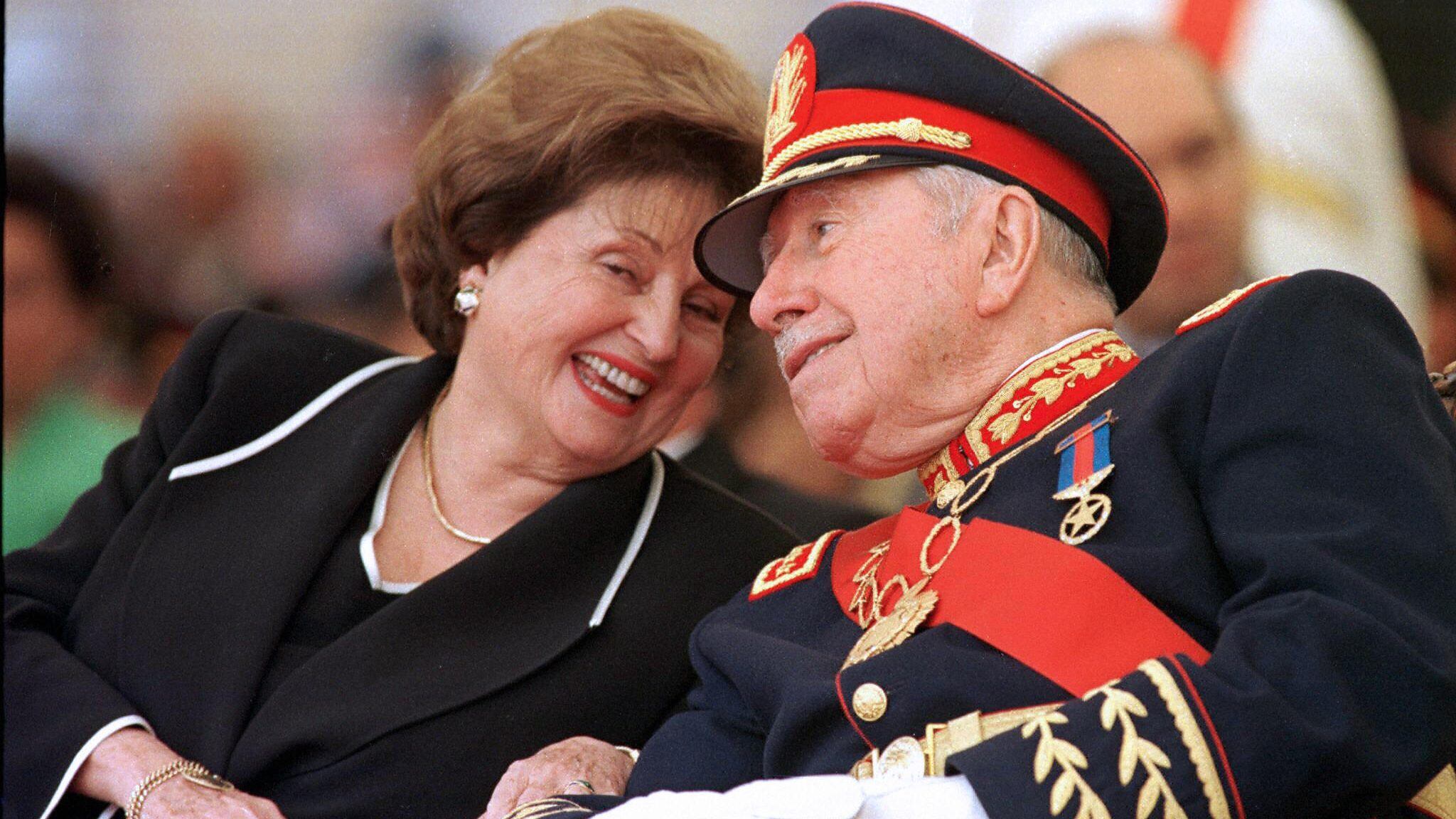 Santiago, CHILE: (FILE) Picture taken 10 March 1998 of Chile's former dictator (1973-90) general Augusto Pinochet (R) listening to his wife Lucia Hiriart during the ceremony marking his retirement from the army command at the Military Academy in Santiago. Pinochet, 91, died 10 December, 2006 at the Military Hospital in Santiago, where he was admitted a week ago following a heart attack. Accused of fraud and human rights abuses during his regime, Pinochet was first ordered under house arrest in late October on other charges only to be released on parole a few days later in deference to his advanced age and ill health. AFP PHOTO/CRIS BOURONCLE (Photo credit should read CRIS BOURONCLE/AFP via Getty Images)