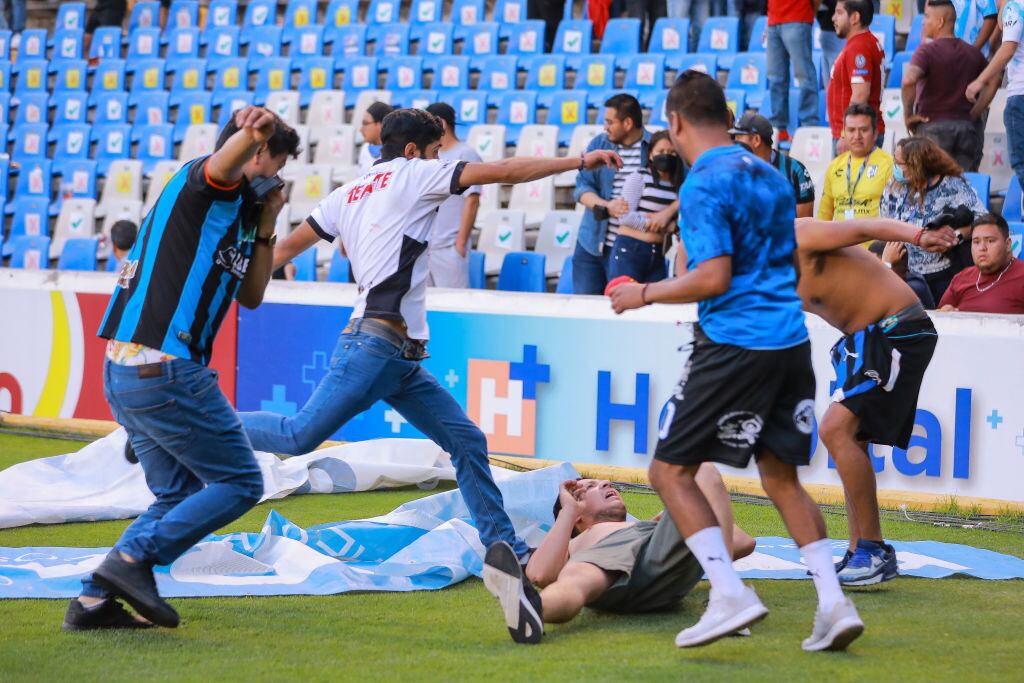 Barristas patean en el suelo a un rival en la cancha de Querétaro