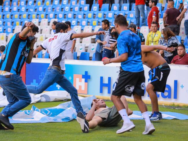 Barristas patean en el suelo a un rival en la cancha de Querétaro