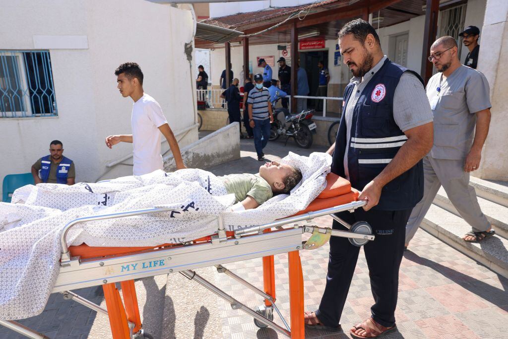 Paramédico asiste a un niño palestino herido tres un bombardeo en Gaza