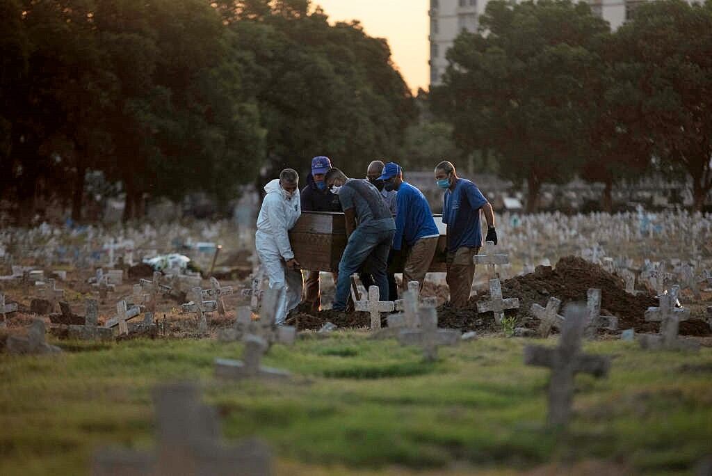 Trabajadores de un cementerio llevan el ataúd de un fallecido por Covid-19 en Brasil