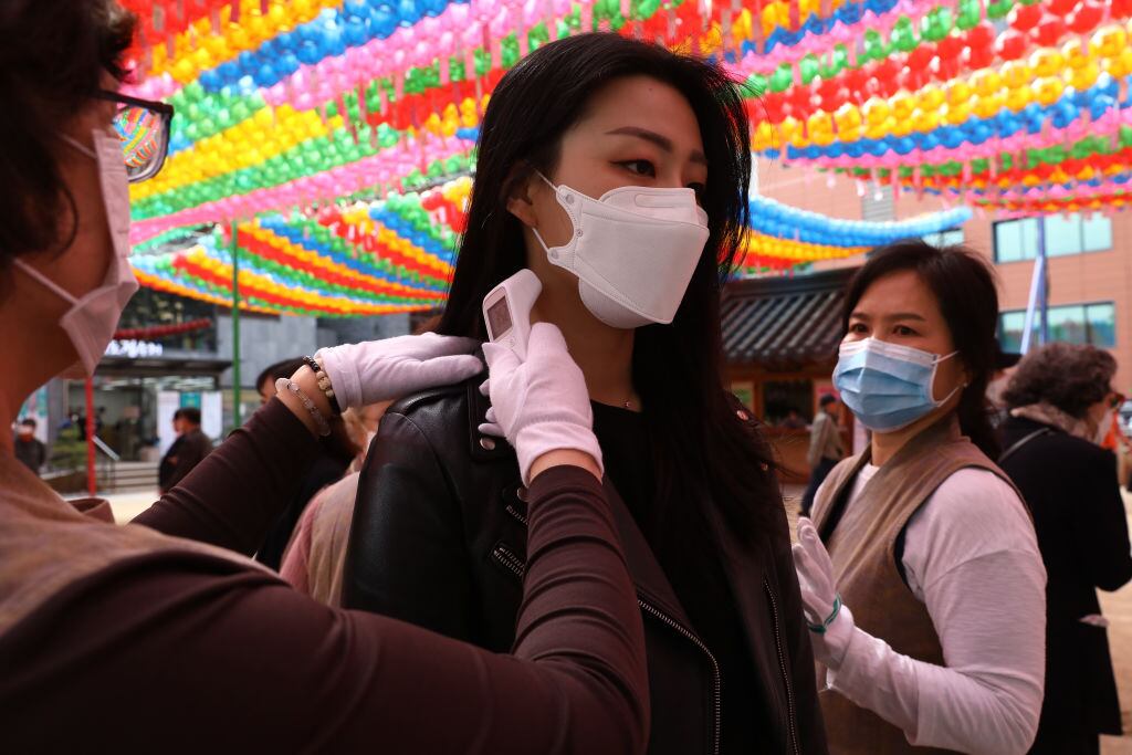 Trabajadores de la salud evalúan la temperatura de ciudadanos en Seúl