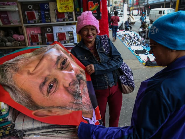 Una mujer compra una toalla con el rostro de Lula en el comercio de Brasil