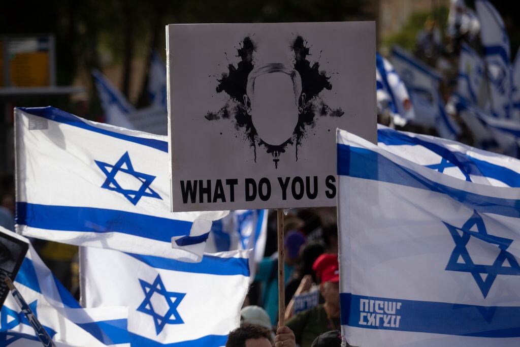 JERUSALEM - MAY 20: Protesters hold signs and flags during a demonstration calling for a hostages deal and against Israeli Prime Minister Benjamin Netanyahu and the government on May 20, 2024 in Jerusalem. As Israel's government reconvenes after a month-long recess, anti-government protesters and supporters of those kidnapped by Hamas on October 7 2023, continue demonstrating on the streets of Jerusalem. (Photo by Amir Levy/Getty Images)