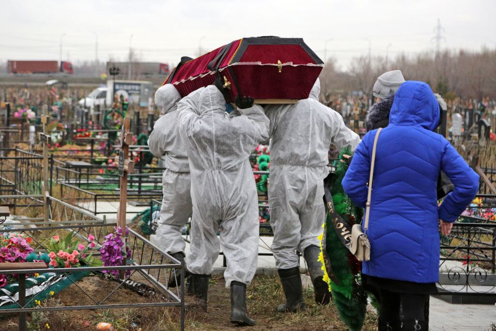Trabajadores realizan el funeral de una víctima en Rusia