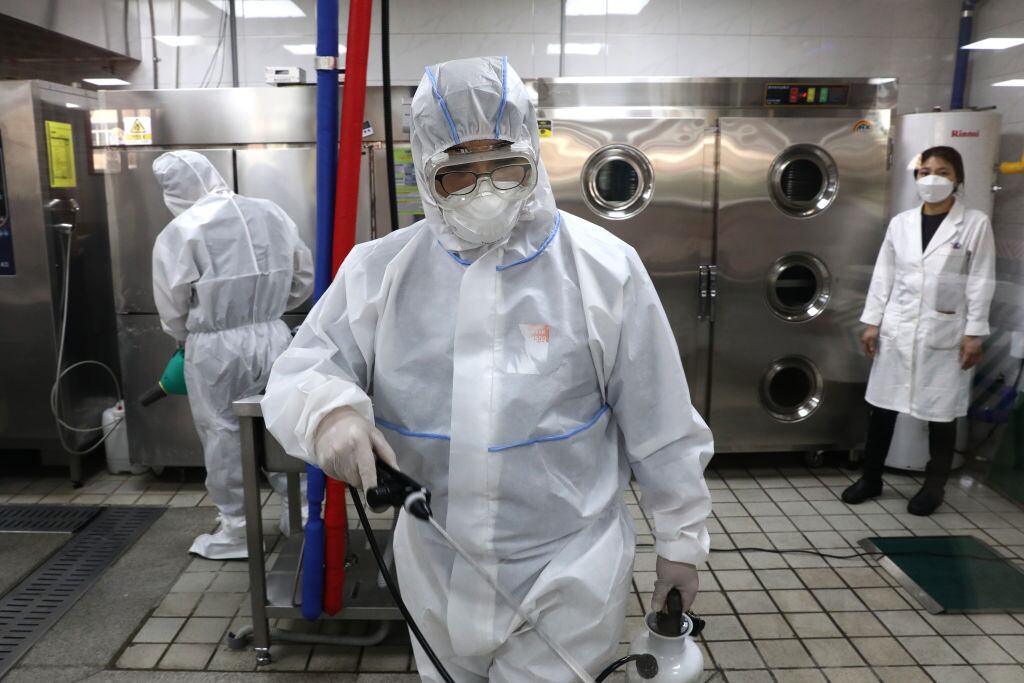 Trabajadores desinfectan edificios en Seúl
