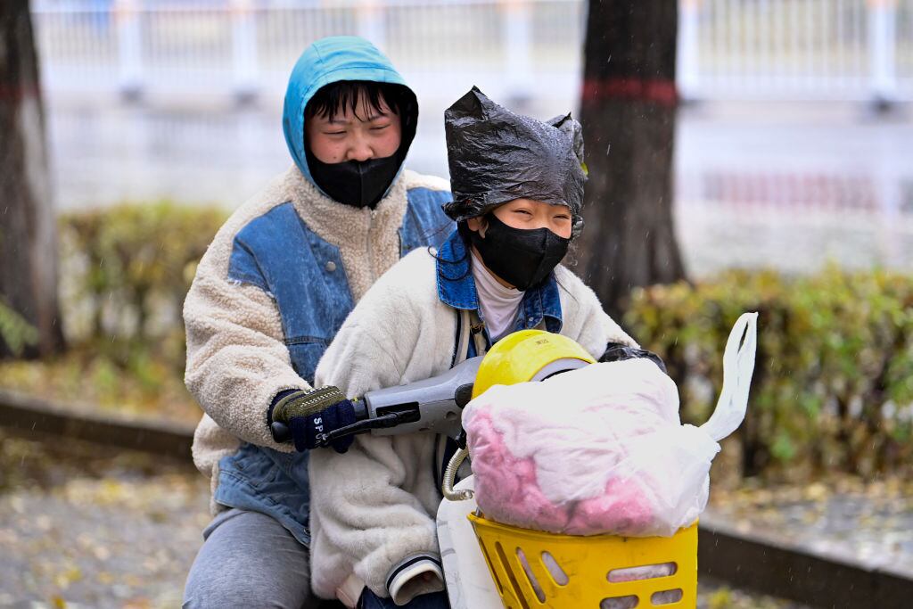 Una familia viaja en su bicicleta con mascarillas en la ciudad Hohhot de China