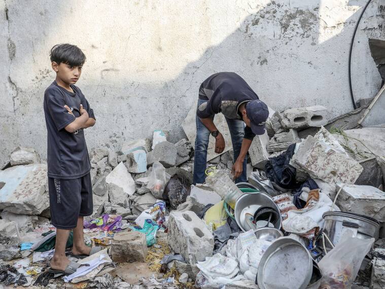Un hombre y su hijo buscan entre los escombros luego de un ataque de Israel contra la zona de Rafah en la Franja de Gaza en Palestina.