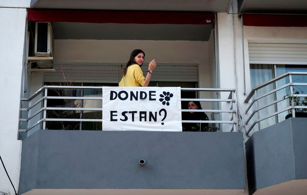 Una mujer junto a un cartel sobre las desapariciones de personas en Uruguay