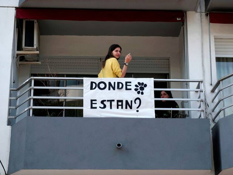 Una mujer junto a un cartel sobre las desapariciones de personas en Uruguay