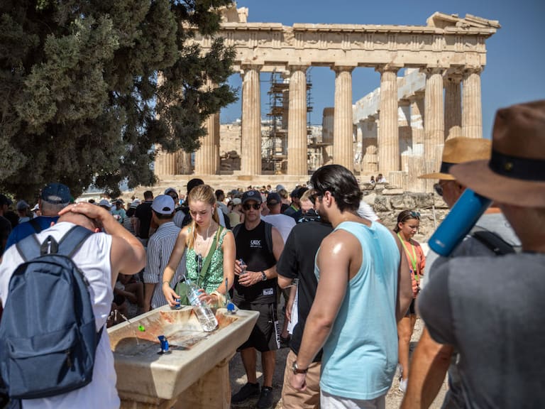 Turistas intentan obtener líquido y captar sombra en la Acrópolis en Grecia