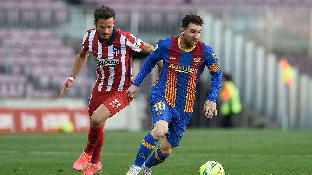 Atletico Madrid's Spanish midfielder Saul Niguez (L) challenges Barcelona's Argentinian forward Lionel Messi during the Spanish league football match FC Barcelona against Club Atletico de Madrid at the Camp Nou stadium in Barcelona on May 8, 2021. (Photo by Josep LAGO / AFP) (Photo by JOSEP LAGO/AFP via Getty Images)