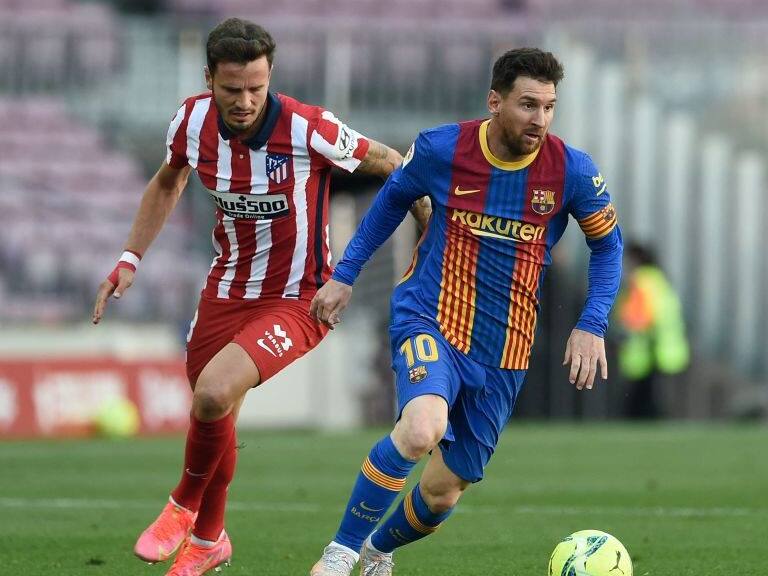 Atletico Madrid's Spanish midfielder Saul Niguez (L) challenges Barcelona's Argentinian forward Lionel Messi during the Spanish league football match FC Barcelona against Club Atletico de Madrid at the Camp Nou stadium in Barcelona on May 8, 2021. (Photo by Josep LAGO / AFP) (Photo by JOSEP LAGO/AFP via Getty Images)