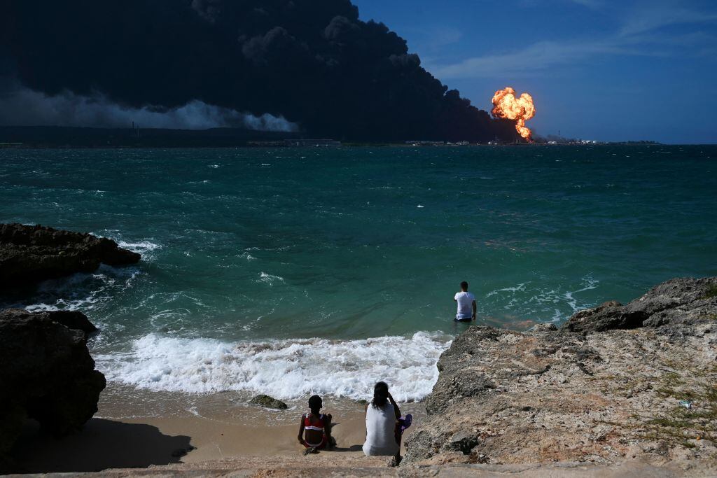 Las personas observan el incendio de los depósitos de crudo en Cuba
