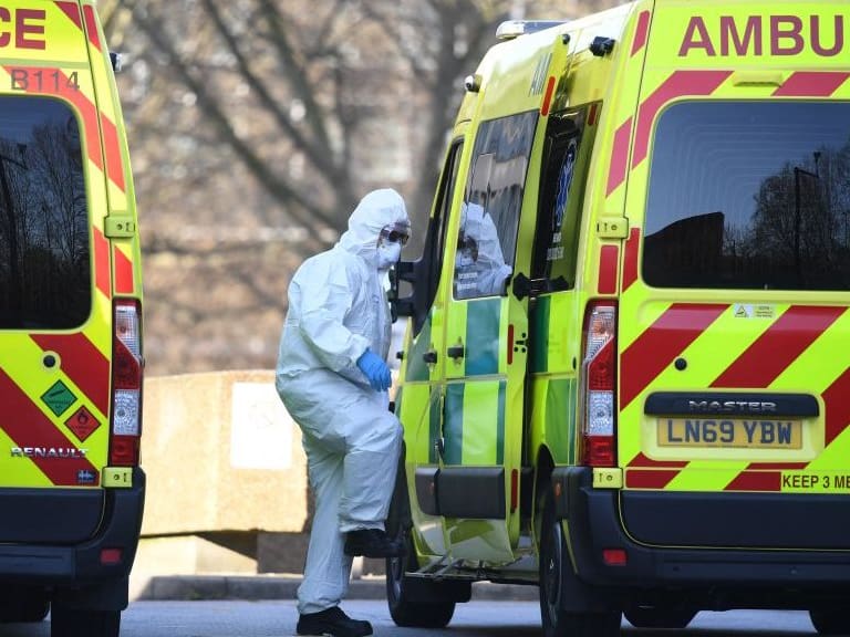 A member of the ambulance service wearing personal protective equipment is seen leading a patient (unseen) into an ambulance at St Thomas&#039; Hospital in London on March 24, 2020. - Britain&#039;s leaders on Tuesday urged people to respect an unprecedented countrywide lockdown, saying that following advice to stay at home would stop people dying of coronavirus. (Photo by Daniel LEAL / AFP) (Photo by DANIEL LEAL/AFP via Getty Images)