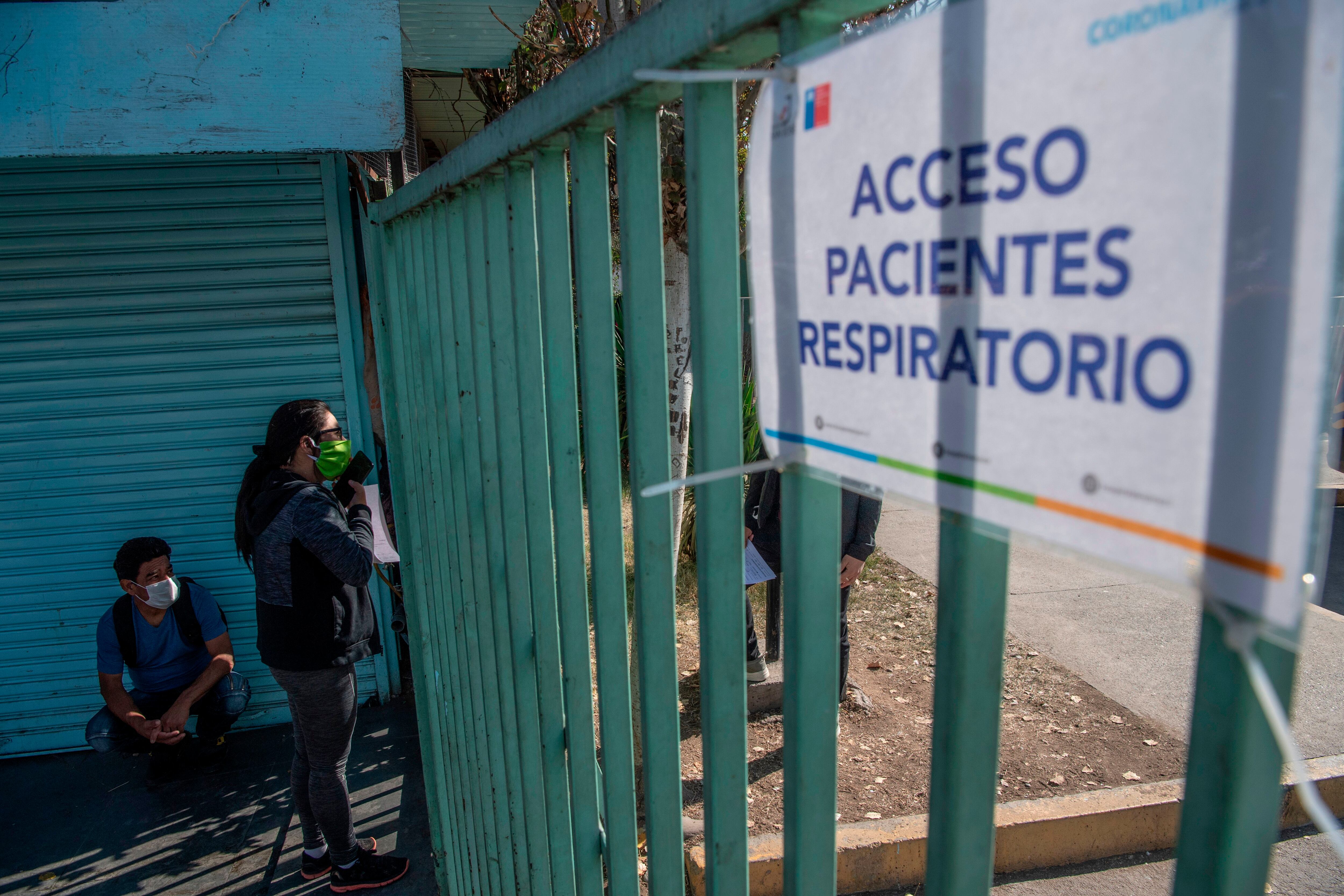 A woman hangs asks for information on COVID-19 coronavirus tests outside a hospital, in Santiago, on May 15, 2020. - Chile's government ordered a mandatory total quarantine for the capital on Wednesday after a 60 percent spike in coronavirus infections in the previous 24 hours. (Photo by MARTIN BERNETTI / AFP) (Photo by MARTIN BERNETTI/AFP via Getty Images)