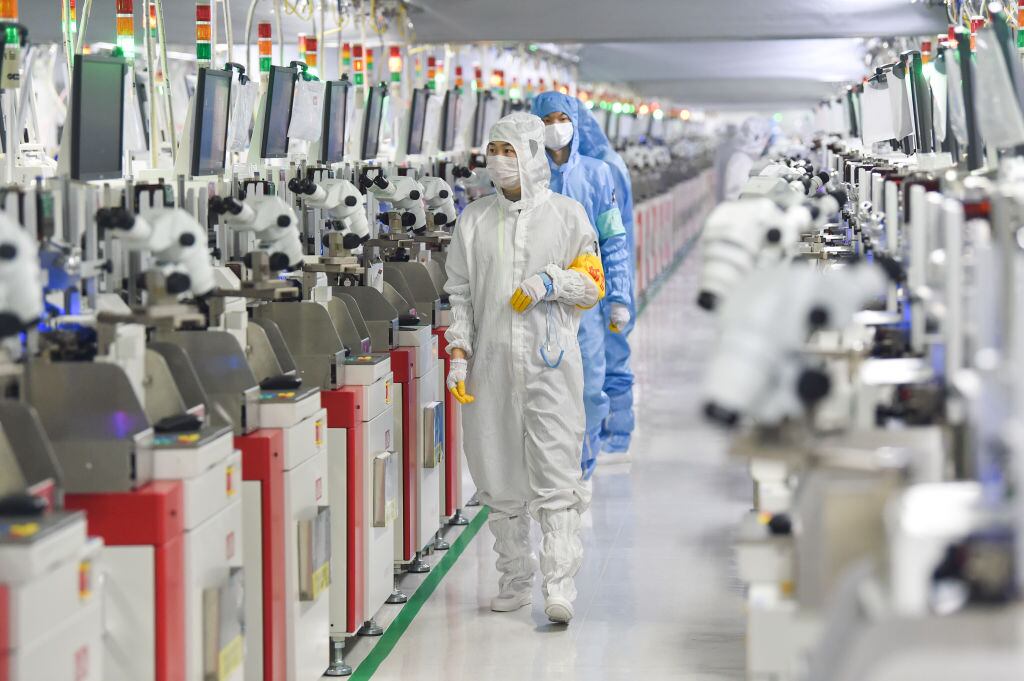 Trabajadores supervisan el funcionamientos de una fábrica de semiconductores en la ciudad de Suqian en China