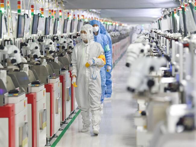Trabajadores supervisan el funcionamientos de una fábrica de semiconductores en la ciudad de Suqian en China