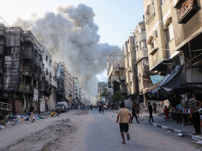 Palestinos observan el humo que se levanta producto de un nuevo bombardeo de Israel sobre la Franja de Gaza en Palestina.