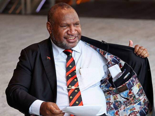 El primer ministro de Papúa Nueva Guinea, James Marape, muestra su chaqueta con fotos suyas en una actividad en Sídney de Australia.