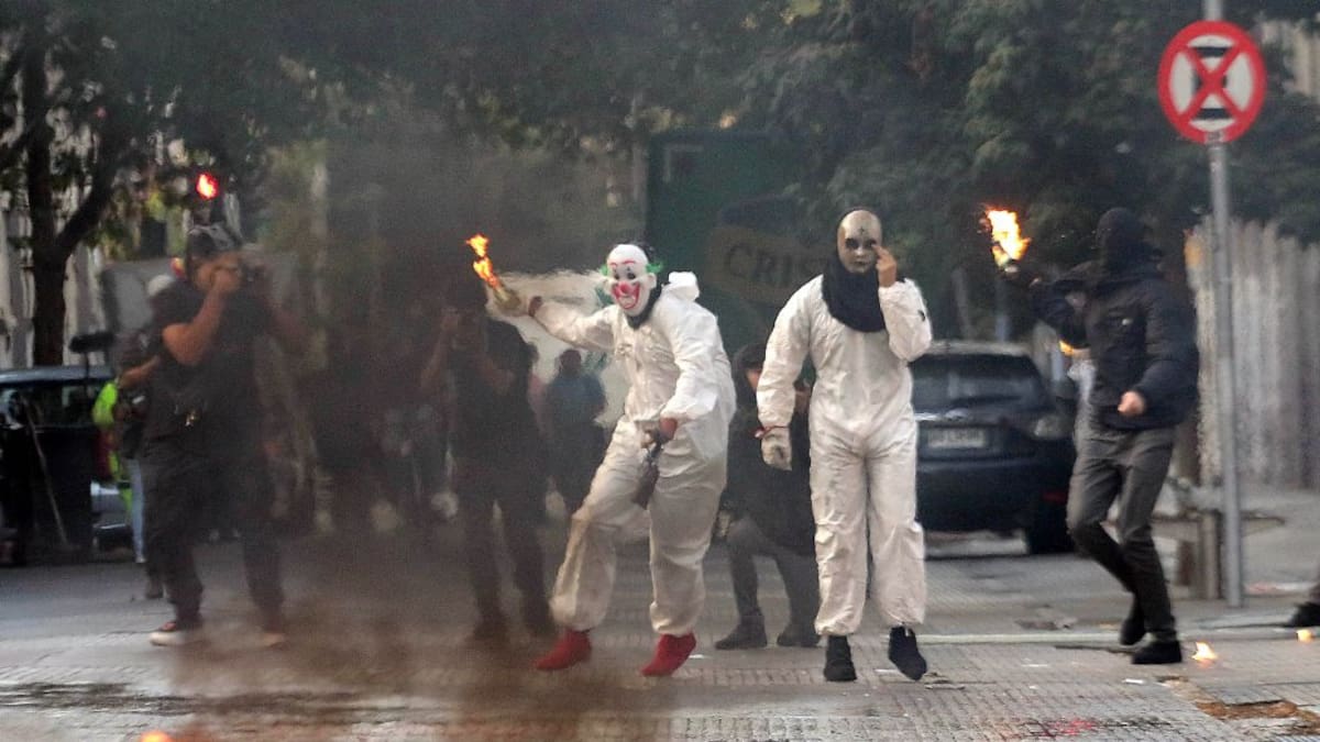 Encapuchados con overoles blancos protagonizan incidentes frente al Instituto Nacional: lanzaron molotov y fuegos artificiales