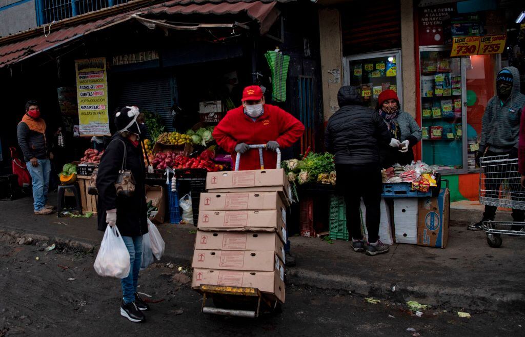 A worker carries boxes at a popular market in Santiago, on June 22, 2020 amid the COVID-19 novel coronavirus pandemic. - Global coronavirus infections topped nine million on Monday as the World Health Organization warned that the pandemic was accelerating. (Photo by Martin BERNETTI / AFP) (Photo by MARTIN BERNETTI/AFP via Getty Images)