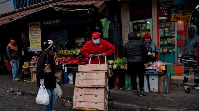 A worker carries boxes at a popular market in Santiago, on June 22, 2020 amid the COVID-19 novel coronavirus pandemic. - Global coronavirus infections topped nine million on Monday as the World Health Organization warned that the pandemic was accelerating. (Photo by Martin BERNETTI / AFP) (Photo by MARTIN BERNETTI/AFP via Getty Images)