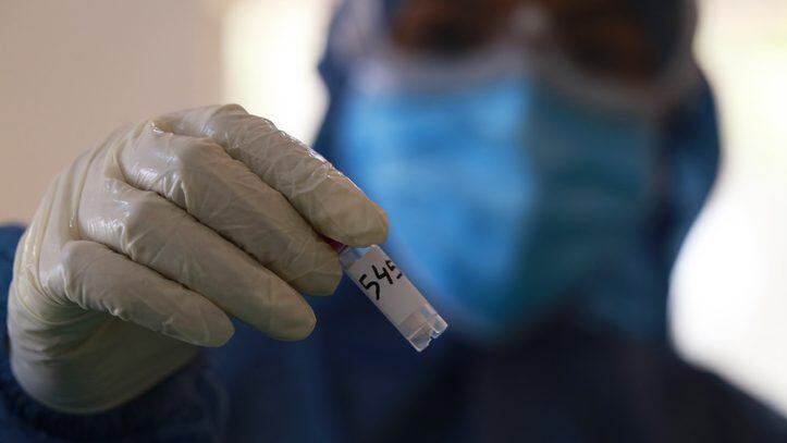 Dhaka, Bangladesh – June 24, 2020: A medical official wearing protective stuffs as she holds up COVID-19 testing kit after collected sample from a resident to test for the COVID-19 coronavirus at a hospital in Dhaka, Bangladesh on June 24, 2020.