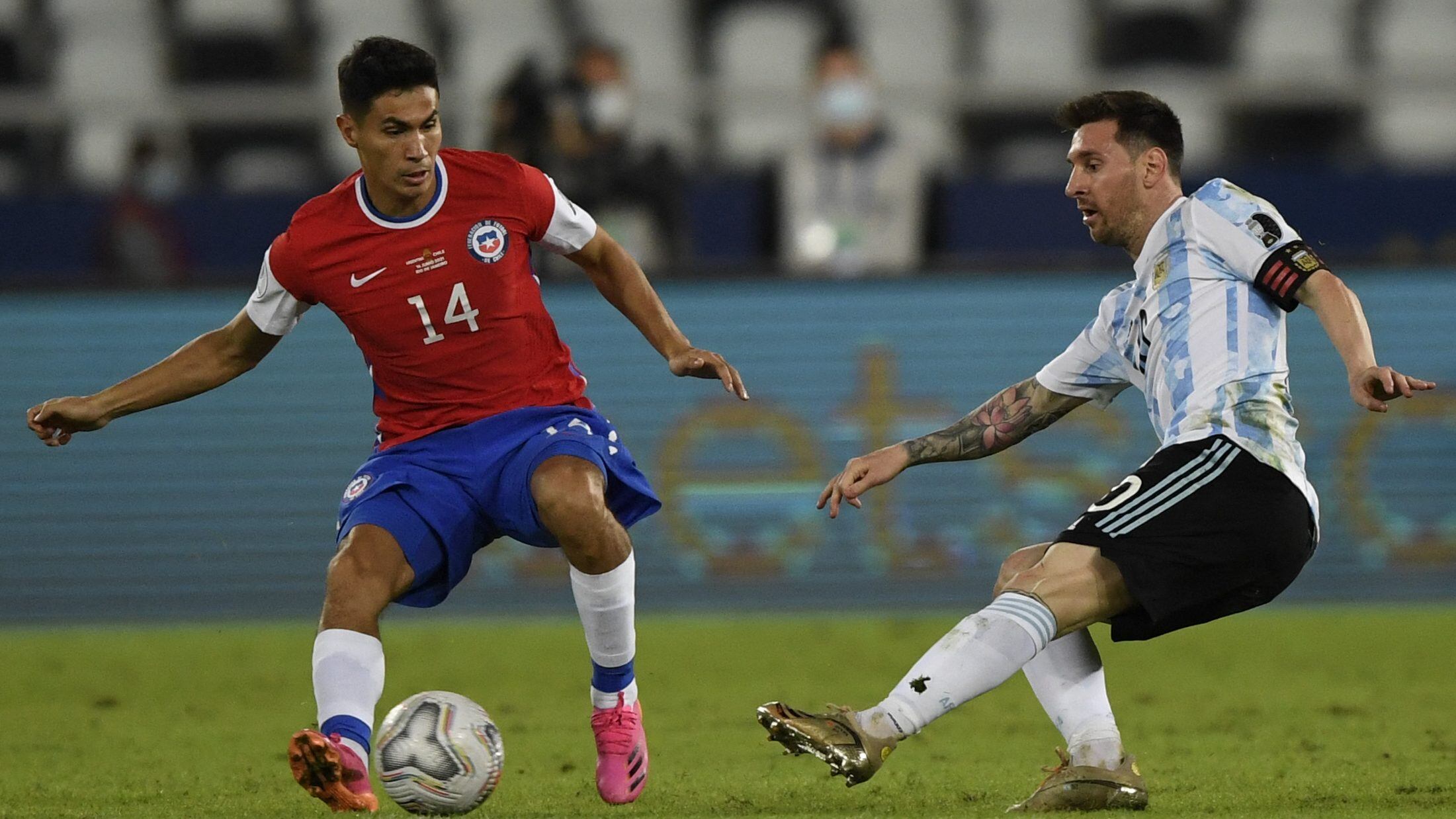 TOPSHOT - Chile's Pablo Galdames (L) and Argentina's Lionel Messi vie for the ball during their Conmebol Copa America 2021 football tournament group phase match at the Nilton Santos Stadium in Rio de Janeiro, Brazil, on June 14, 2021. (Photo by MAURO PIMENTEL / AFP) (Photo by MAURO PIMENTEL/AFP via Getty Images)