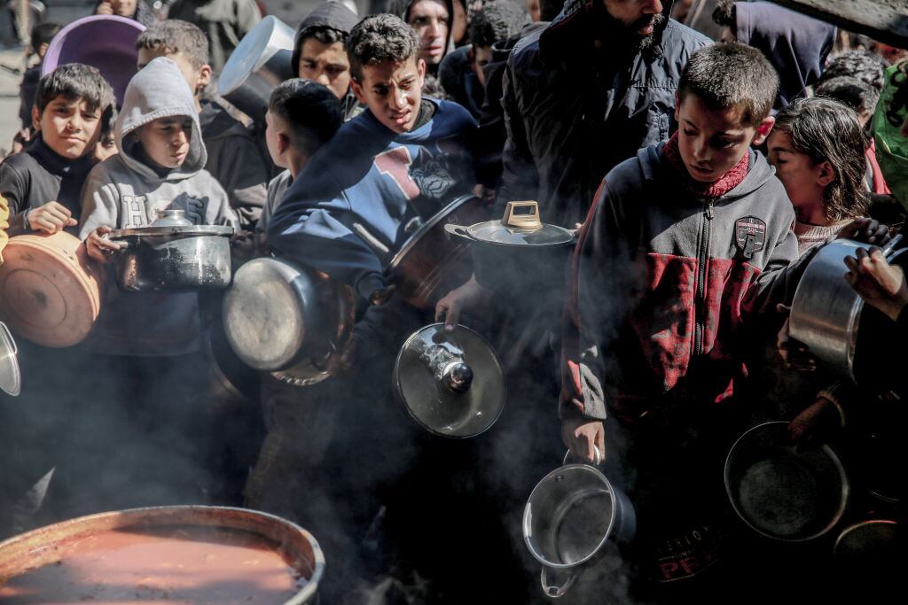 Niños palestinos esperan por algo de comida, en medio de la crisis de hambre que enfrenta la población que sobrevive en la Franja de Gaza de Palestina.