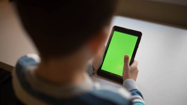 a series of photos of a little boy at a desk with a green screen tablet