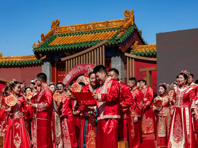 SHENYANG, CHINA - SEPTEMBER 22: Newly-wed couples attend a group wedding in traditional Chinese style under the witness of their families and friends in the South Square at Shenyang Imperial Palace on September 22, 2024 in Shenyang, Liaoning Province of China. (Photo by Cai Jingyu/VCG via Getty Images)