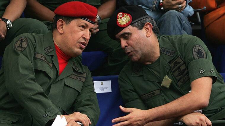 Caracas, VENEZUELA: Venezuelan President Hugo Chavez (L) chats with Defense minister General Raul Baduel, during the inauguration ceremony of the Army?s Commander in Chief, Gral. Gustavo Rangel (out of picute) in Caracas, 11 August 2006. Chavez branded the US Government as "tyrannical and dictatorial" and added "it is there where democracy is needed", referring to a statement by the top US diplomat for the Americas, Tom Shannon, who wished the Venezuelan leader joined in the calls for a democratic change in Cuba. AFP PHOTO/Juan BARRETO (Photo credit should read JUAN BARRETO/AFP via Getty Images)