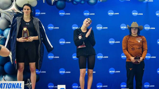 ATLANTA, GA - MARCH 17: University of Pennsylvania swimmer Lia Thomas accepts the winning trophy for the 500 Freestyle finals as second place finisher Emma Weyant and third place finisher Erica Sullivan watch during the NCAA Swimming and Diving Championships on March 17th, 2022 at the McAuley Aquatic Center in Atlanta Georgia. (Photo by Rich von Biberstein/Icon Sportswire via Getty Images)
