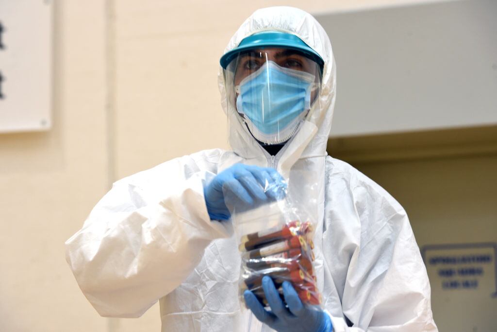 Un trabajador de la salud transporta exámenes en medio de la pandemia en Italia