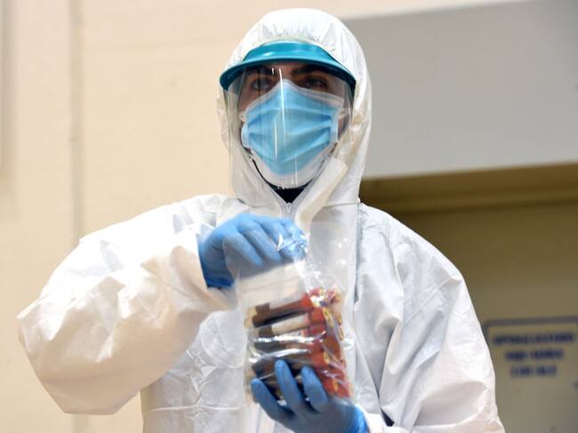 Un trabajador de la salud transporta exámenes en medio de la pandemia en Italia